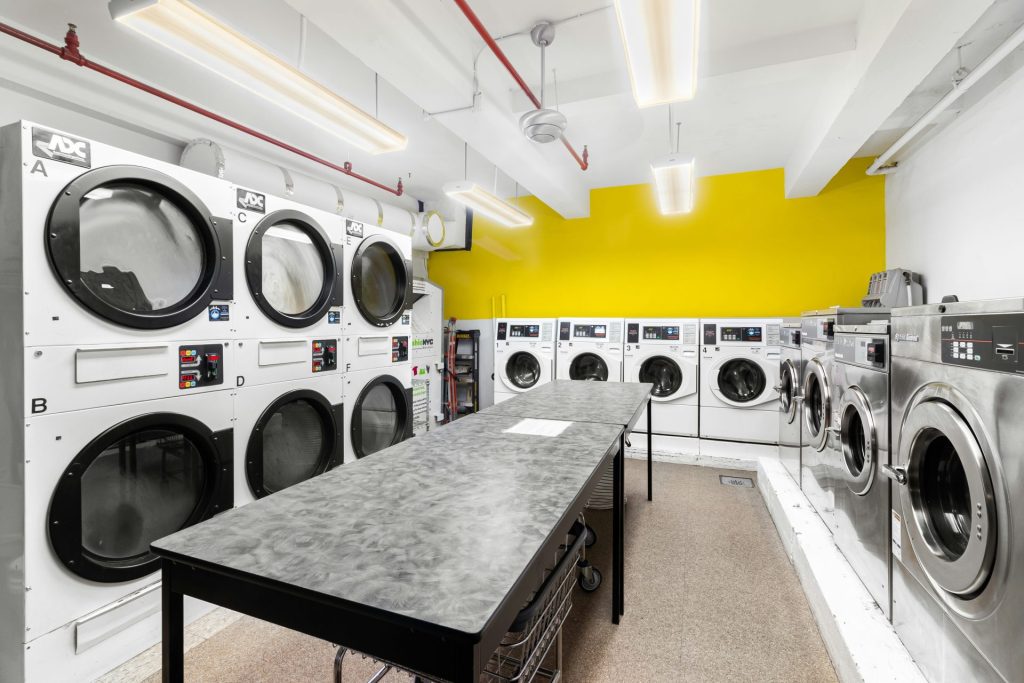 A large laundry room with washers and dryers